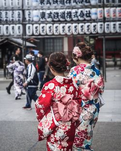 Rear view of woman in kimonos walking on street