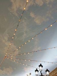 Low angle view of overhead cable cars against sky