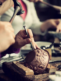 Cropped image of people carving at workshop