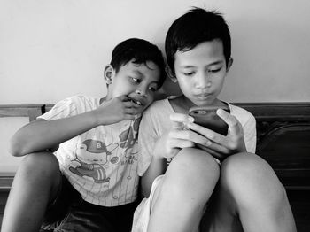 Friends sitting on mobile phone at home