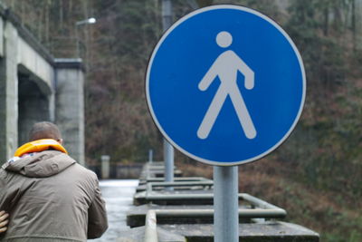 Rear view of man sign on road