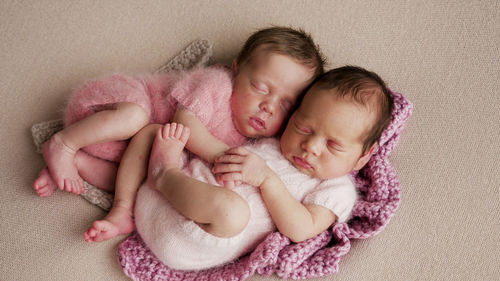 Two girls twins newborn sleep in bed