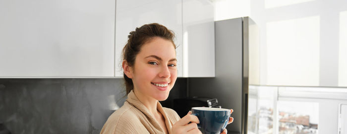 Young woman using mobile phone at home