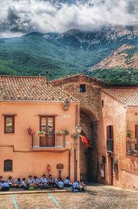 Houses in town by mountains against sky