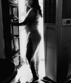 Side view of woman standing at home