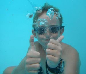 Portrait of boy gesturing thumbs up in swimming pool