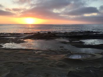 Scenic view of beach against sky during sunset