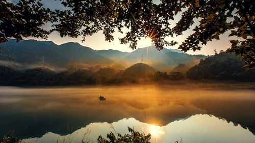 Scenic view of lake against sky during sunset