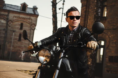 Man wearing sunglasses while sitting on motorcycle