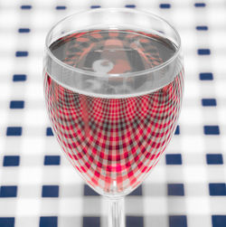 High angle view of wineglass on checked pattern table