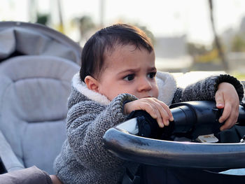 Little boy in his baby carriage angry because he can't walk child childhood one person.