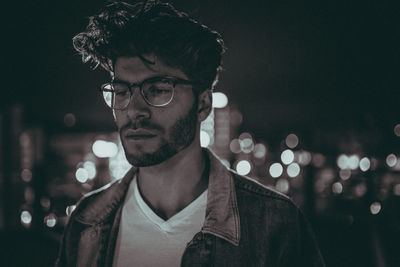 Young man looking away while standing outdoors