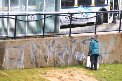 Rear view of man walking by building