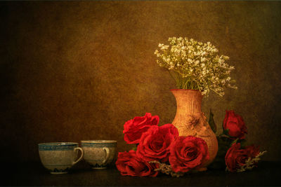 Close-up of rose bouquet on table against wall