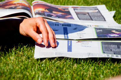 Close-up of man reading newspaper on field