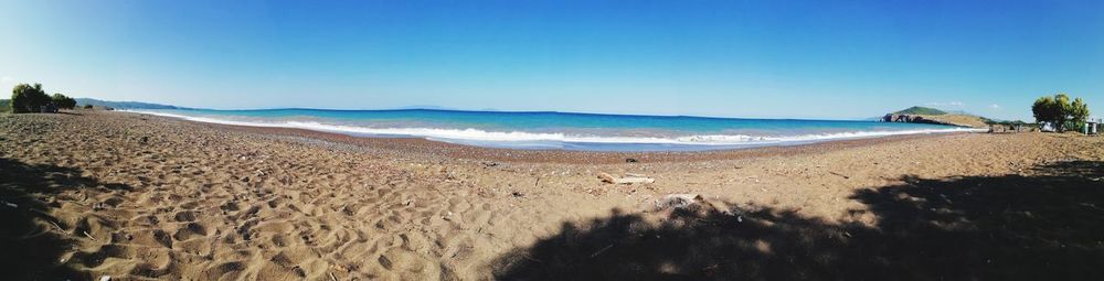 Scenic view of beach against clear blue sky