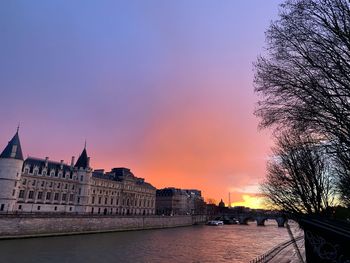 Buildings at waterfront during sunset