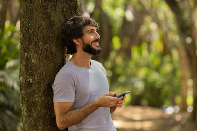 Young man at park on a beautiful sunny day with mobile phone.  working  leisure. green and nature 