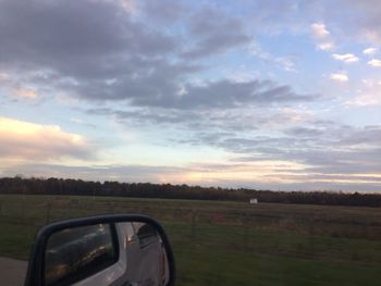 Car on field against sky during sunset