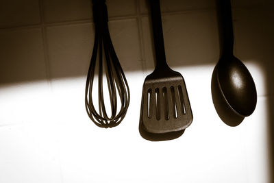 Close-up of cooking utensil hanging against wall at home