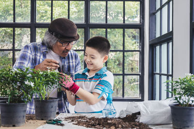 Happy friends looking at potted plant