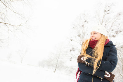 Young woman walking on snow covered landscape
