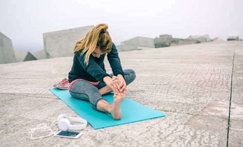 Full length of woman sitting against clear sky