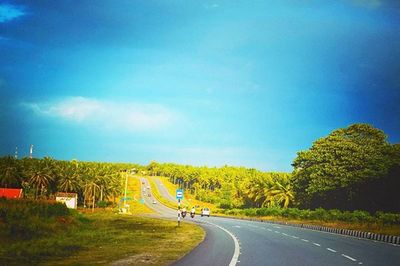 Empty road with trees in background