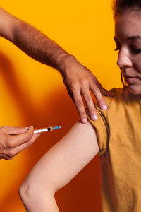 Cropped hand of doctor vaccinating patient