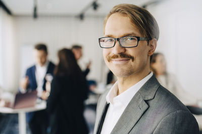 Portrait of smiling businessman standing in office seminar