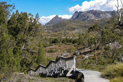 Scenic view of mountaineous landscape with boardwalk against sky