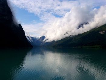 Scenic view of lake by mountains against sky