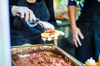 Midsection of man preparing food at market stall