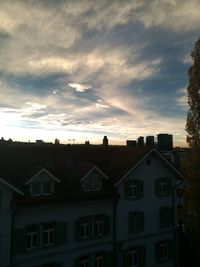 Residential buildings against sky at sunset