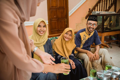 Woman serving juice to guests at home