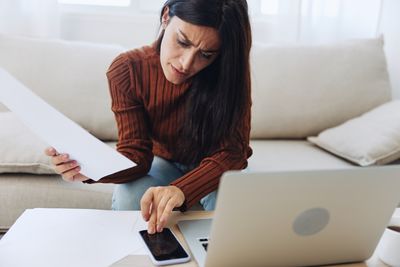 Side view of woman using laptop at home