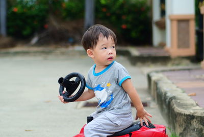 Portrait of boy riding toy car