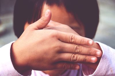 Boy hiding his face with his hands