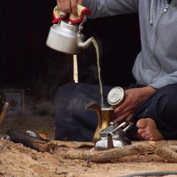 Midsection of man pouring tea