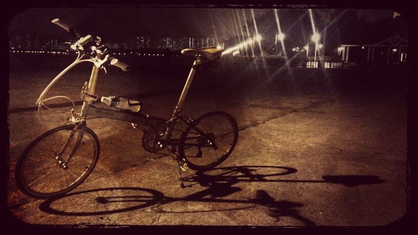 bicycle, transportation, land vehicle, mode of transport, night, parked, stationary, parking, illuminated, auto post production filter, street, transfer print, outdoors, no people, absence, wheel, cycle, built structure, wall - building feature, light - natural phenomenon