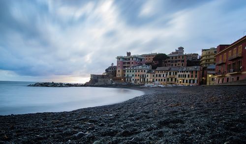 Buildings by sea against sky