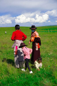 Rear view of tibetan woman standing on grassy field