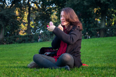 Full length of woman sitting on field