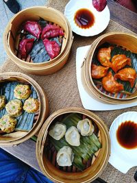 Directly above shot of various dim sums in baskets on table