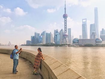 People on river with city in background