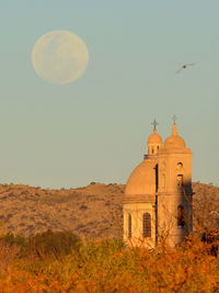 Church on field against sky at dusk