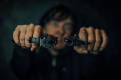 Close-up portrait of young man holding camera