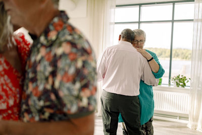 Rear view of senior man dancing with woman in dance class