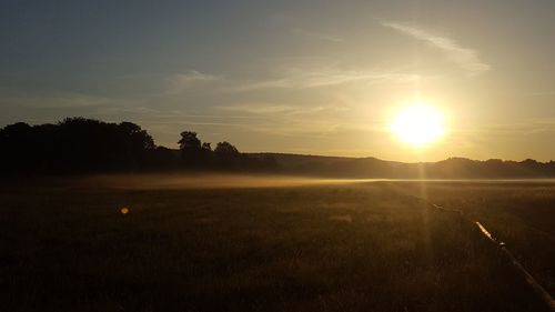 Scenic view of field against sky during sunset