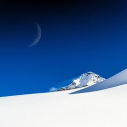 Scenic view of snowcapped mountains against clear blue sky